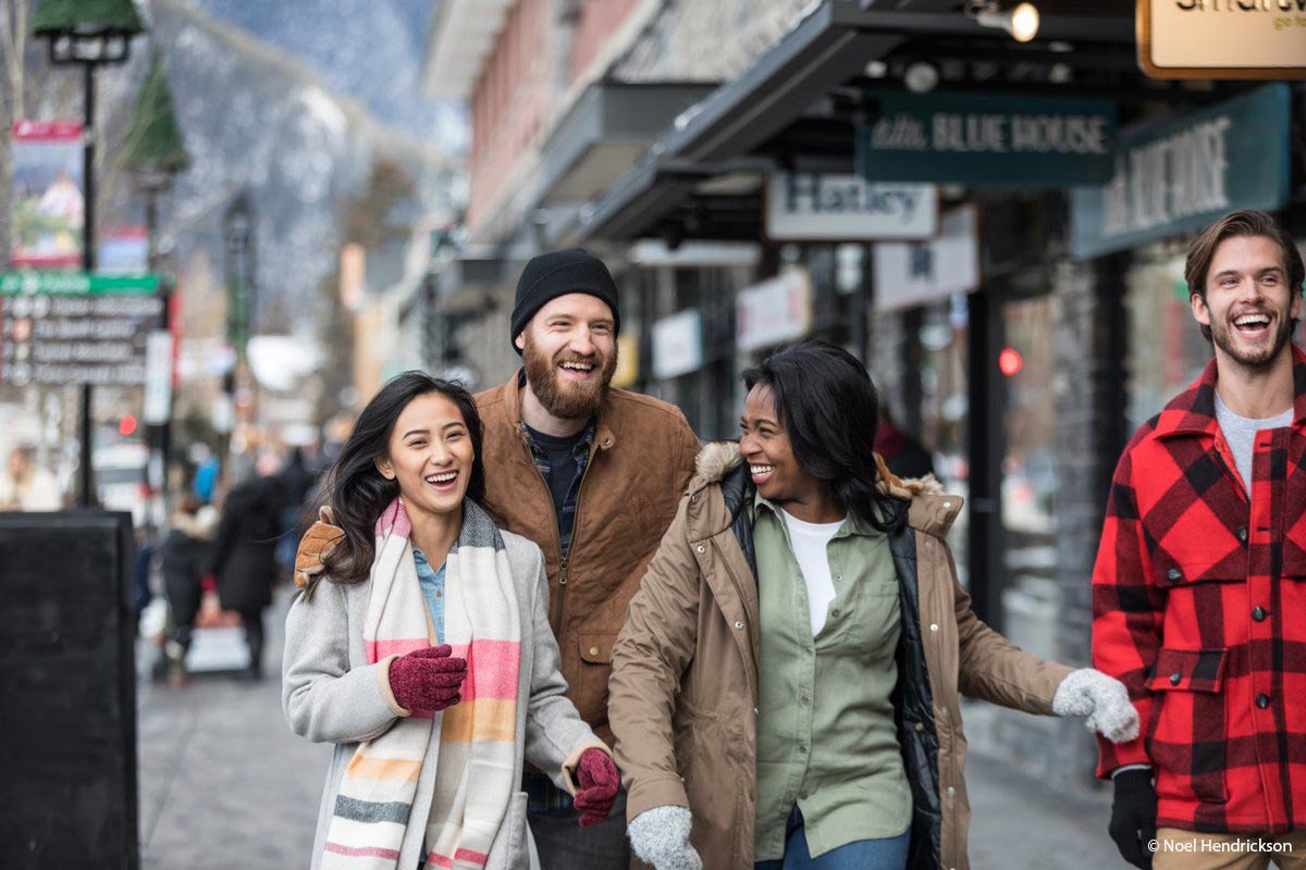 Getting Around Banff on foot - A group of friends walks along Banff Avenue
