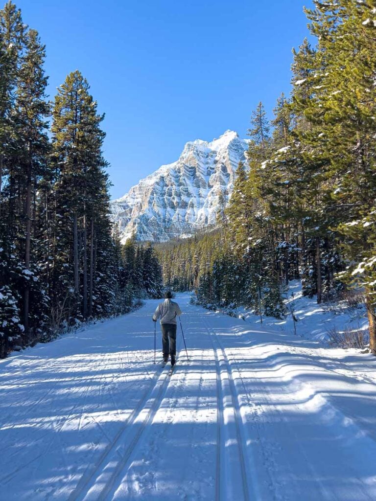 Dan Brewer, owner of the Travel Banff Canada blog, cross country skis on Moraine Lake Road in winter.