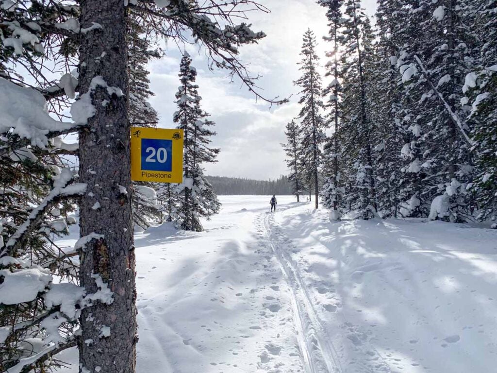 Celine Brewer skis past a lake on the Pipestone Trail near Lake Louise.