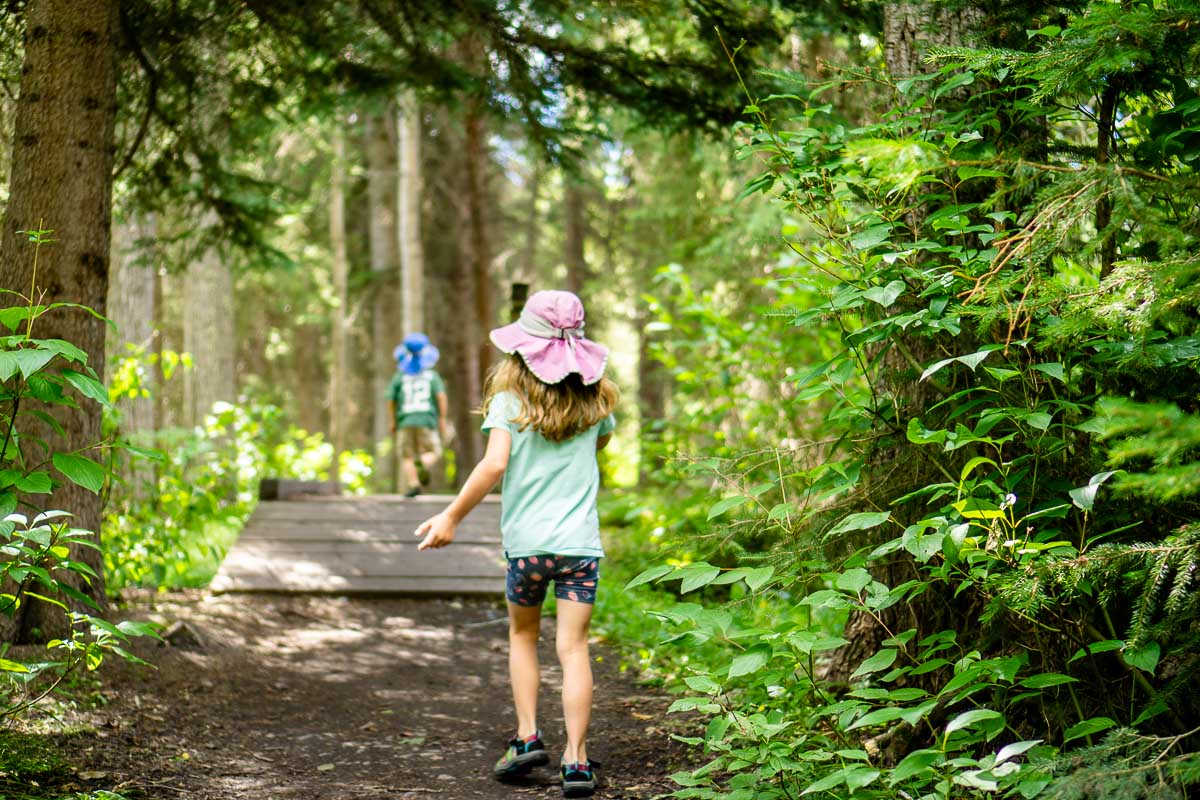 two young kids enjoy an easy hike in the Banff townsite along the Fenland Loop trail.