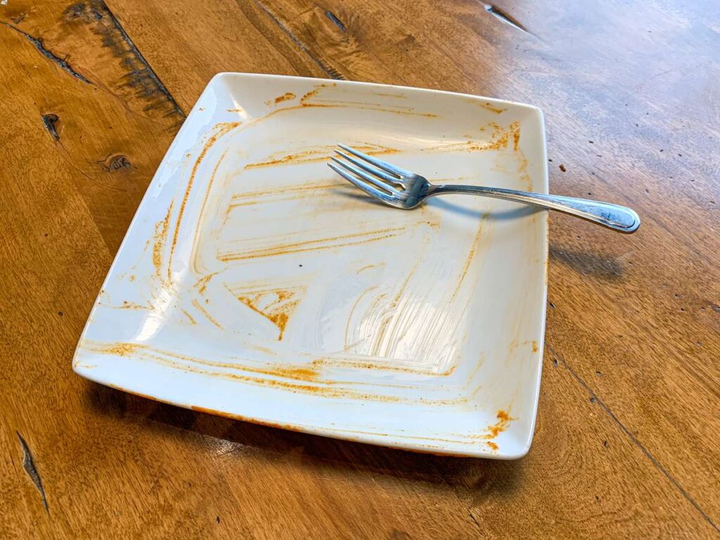 canmore takeout food - an empty butter chicken plate from Curry's Curries