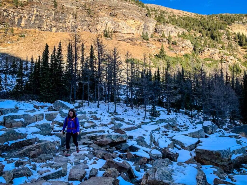 A woman hikes across rocks on the Big Beehive hike - Banff National Park