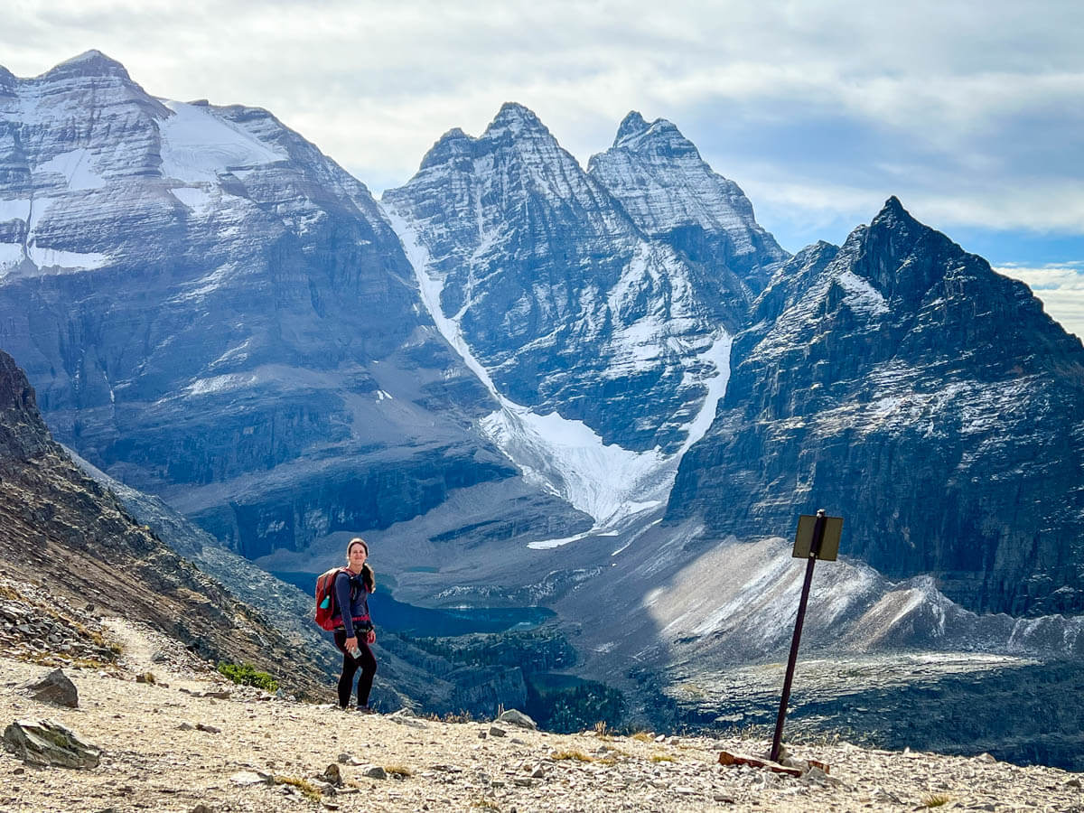 A hiker enjoys views of glaciers and lakes from Wiwaxy Gap