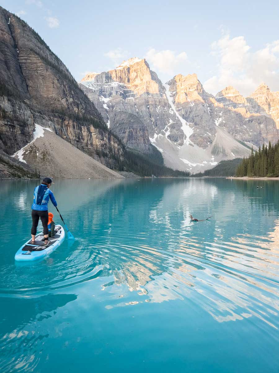 Woman with son Paddle Boarding on Moraine Lake at Sunrise.