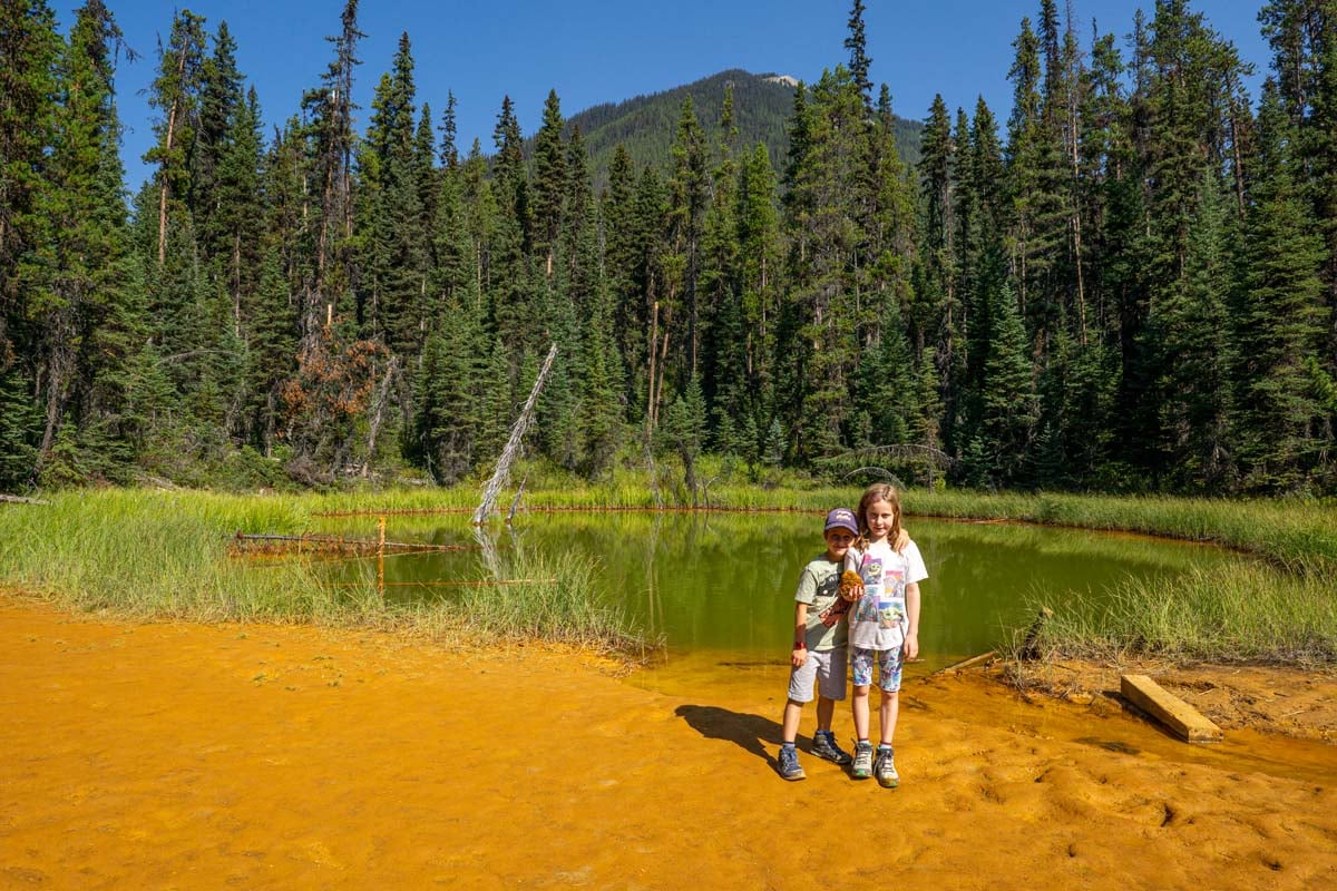 The Brewer kids, from the Travel Banff Canada team, stand next to the very colorful Paint Pots in Kootenay National Park in BC, Canada.