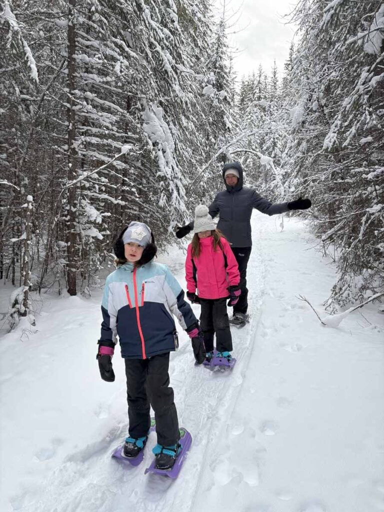 A family enjoys a guided snowshoeing tour with Among the Trees Canada.