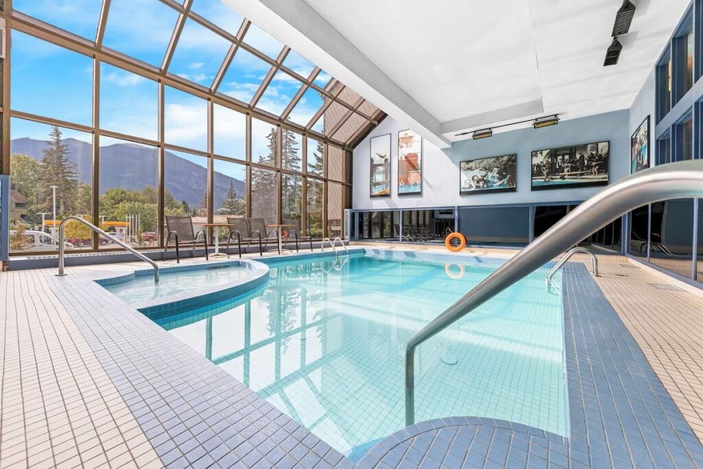 the indoor swimming pool at the Best Western Plus Banff hotel features a wall of windows with amazing mountain views.