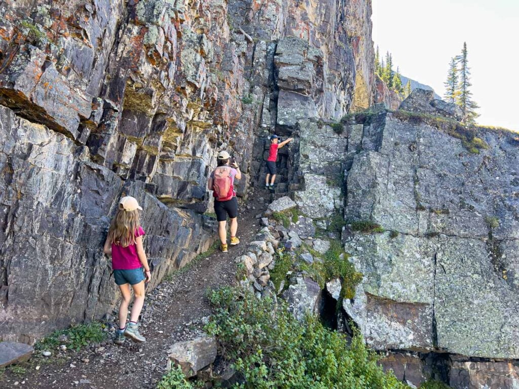 An 8-year old boy begins a scramble up a rock on the Lake McArthur High Level Trail.