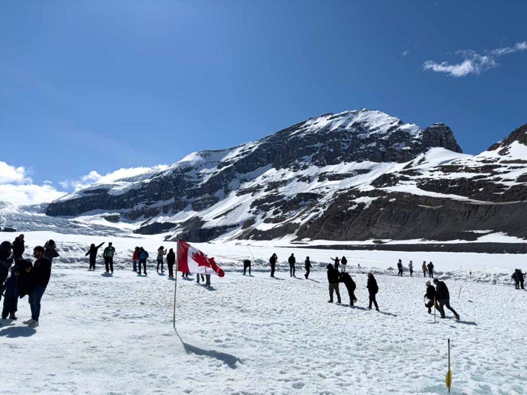 Excited tourists explore the safe visiting area on the Athabasca Glacier on the Columbia Icefield tour by Pursuit.