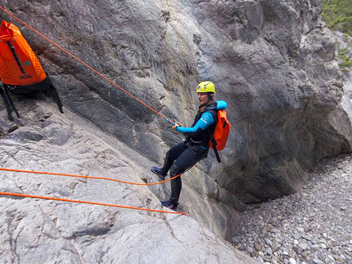 Celine Brewer repels down a slot canyon on the Heart Creek Canyoning Tour by Banff Canyoning.