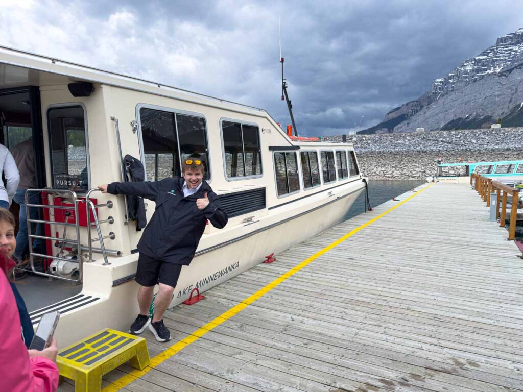 A guide welcomes guests aboard the boat before the Lake Minnewanka Cruise tour.
