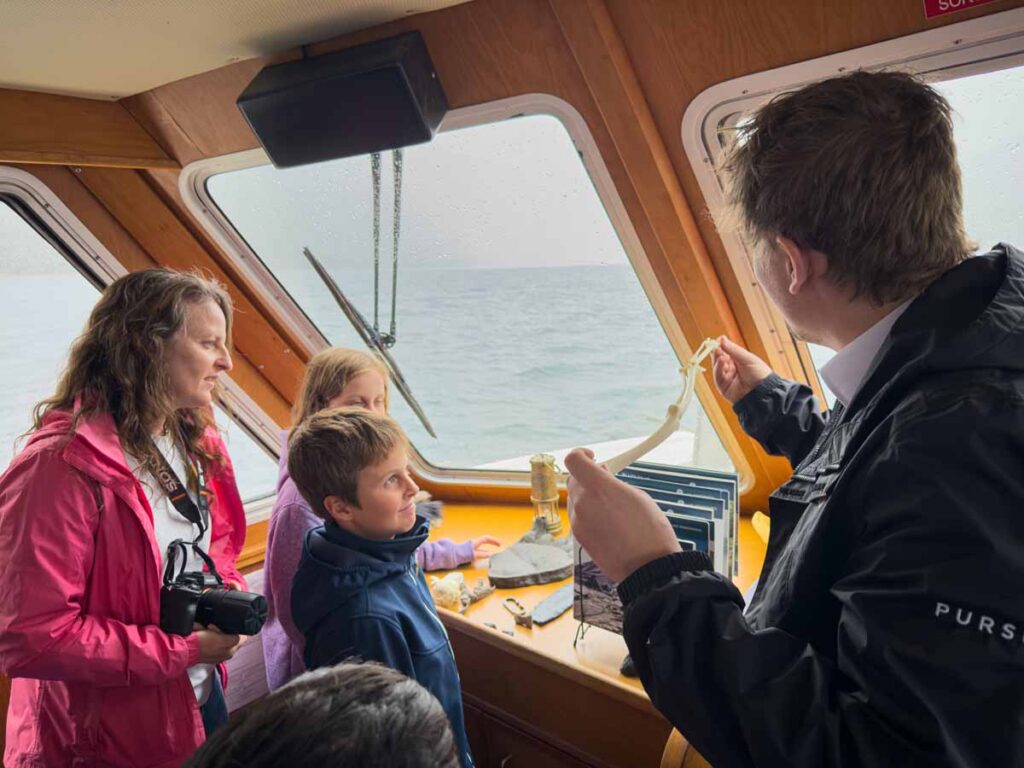 Celine Brewer, owner of TravelBanffCanada.com, talks to the interpretive guide with her kids while on the Lake Minnewanka Cruise.