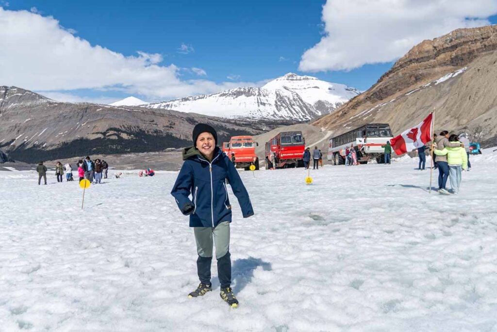 A 9-year old boy has a big smile while having fun on the snow on the Athabasca Glacier in Jasper National Park.