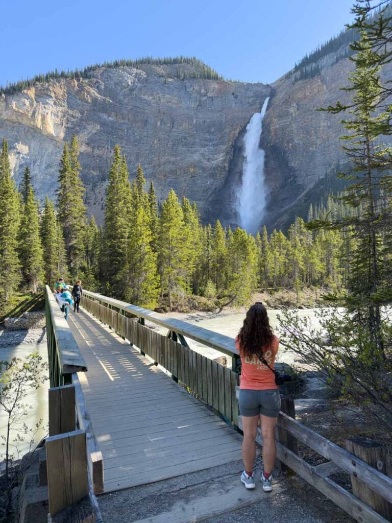 Celine Brewer, owner of TravelBanffCanada.com, takes photos of Takakkaw Falls from the bridge over the Yoho River.