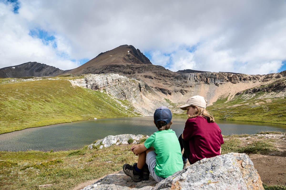 Helen Lake Hike - Banff (1) two kids sit in front of Helen Lake