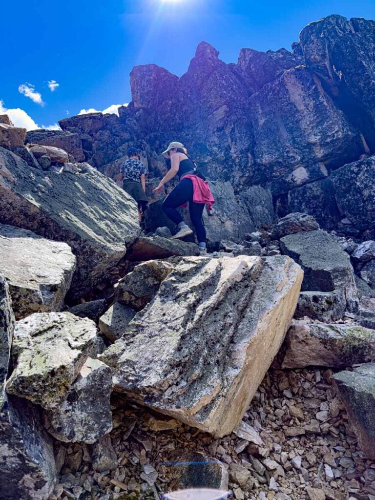 Celine Brewer, owner of Travel Banff Canada, climbs through a boulder field while hiking the All Souls Prospect trail at Lake O'Hara.
