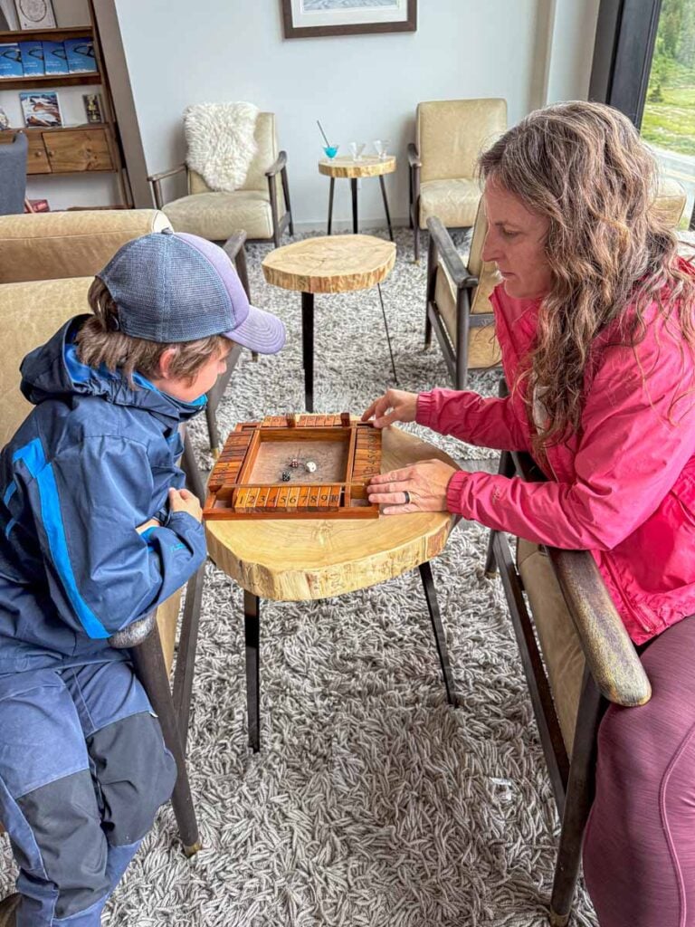 Celine Brewer plays a board game in the Moraine Lounge with her son during a family stay at the Glacier View Lodge.