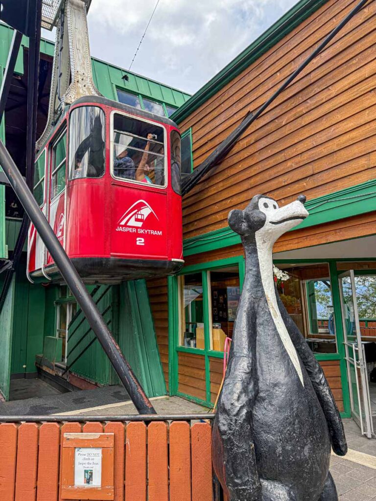 'Jasper the Bear' stands in front of tram car at the Jasper SkyTram Lower Terminal.