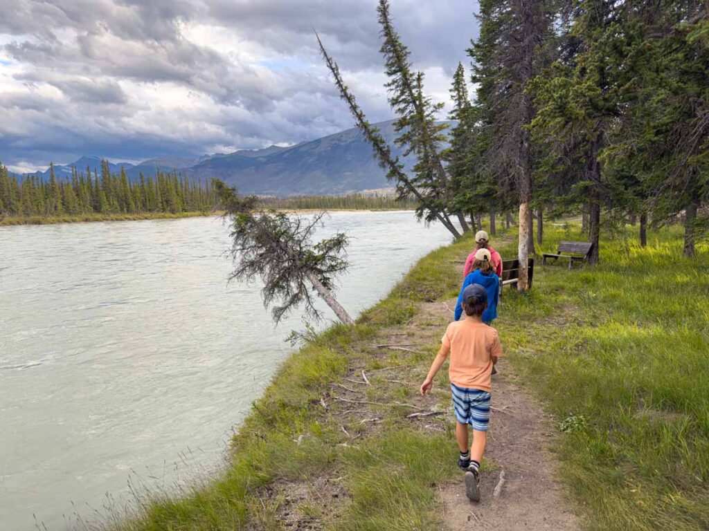 The Brewer family goes for a walk along the Athabasca River during their stay at the Pine Bungalows in the Jasper townsite.