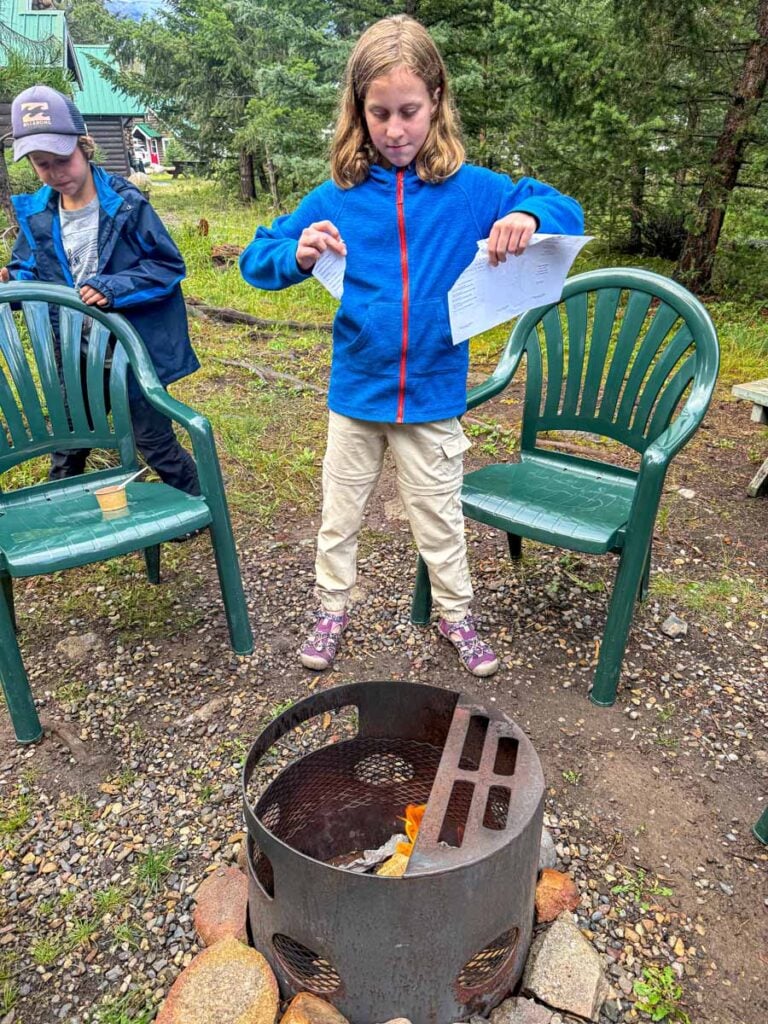 The Brewer family tries to start a campfire in their private firepit at the Pine Bungalows in Jasper, Canada.