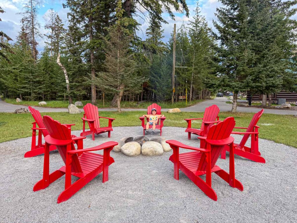 A 10-year old boy enjoys the campfire during his family stay at the Pine Bungalows in the Jasper townsite.