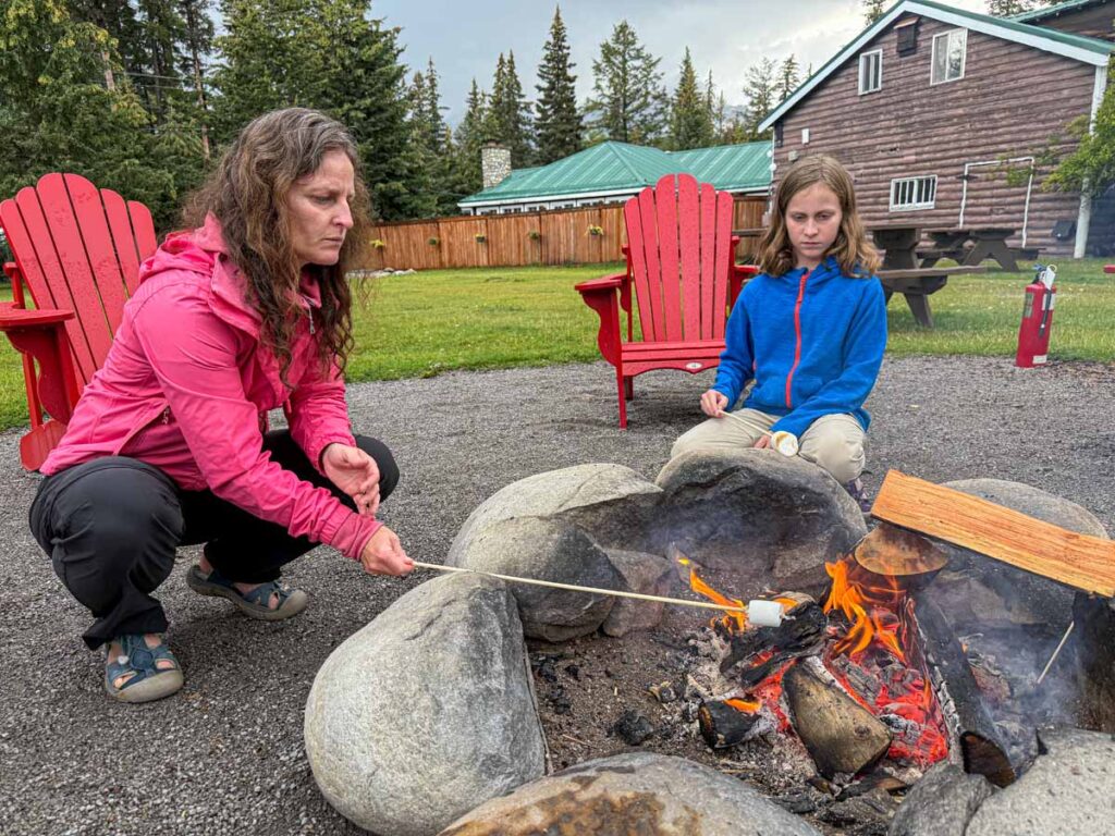 Celine Brewer, owner of TravelBanffCanada.com, roasts marshmallows with her daughter during a family stay at the Pine Bungalows in Jasper, Canada.