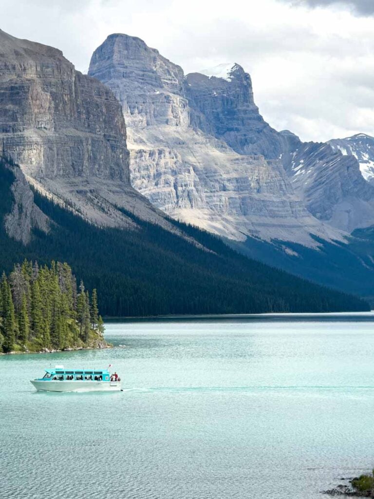 A Maligne Lake Cruise boat beneath towering Rocky Mountains.