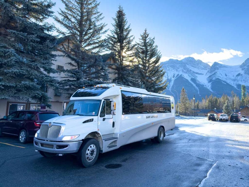 The Banff Airporter is parked in front of the Canmore Coast Hotel.