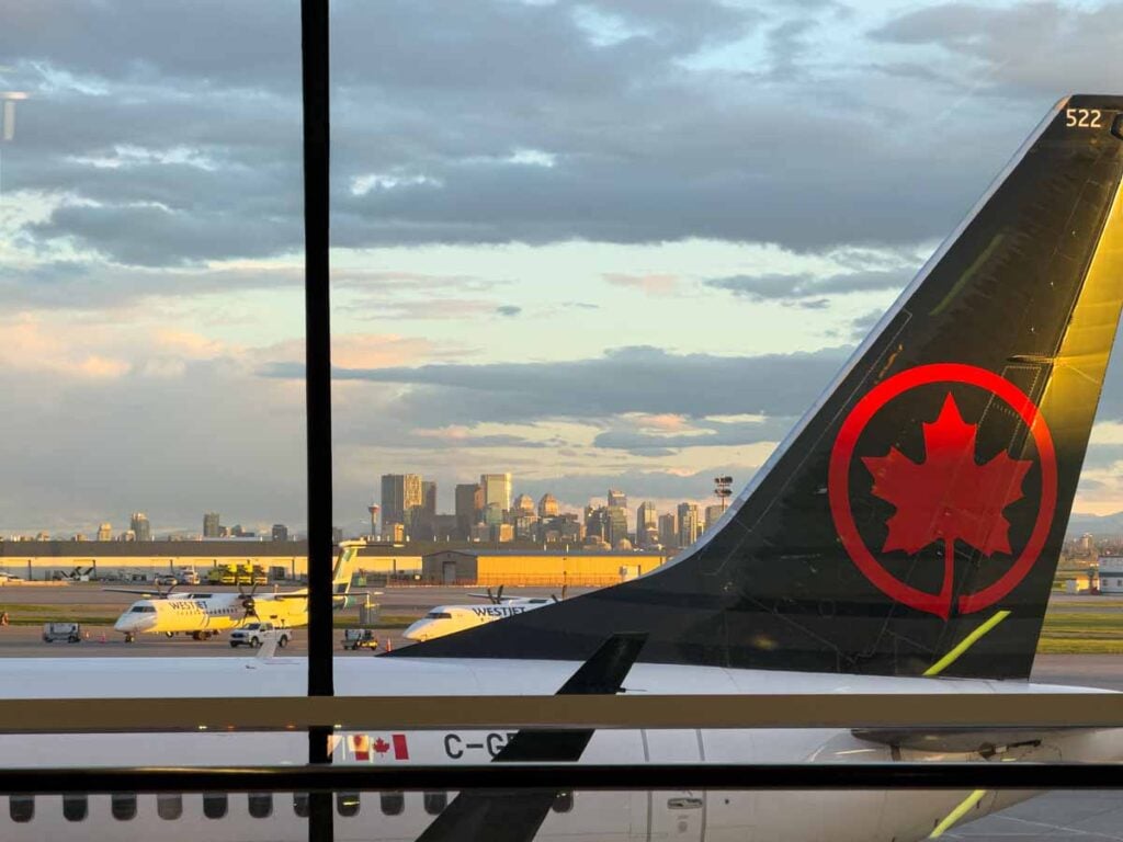An Air Canada plane at the Calgary Airport (YYC) with downtown Calgary in the background.
