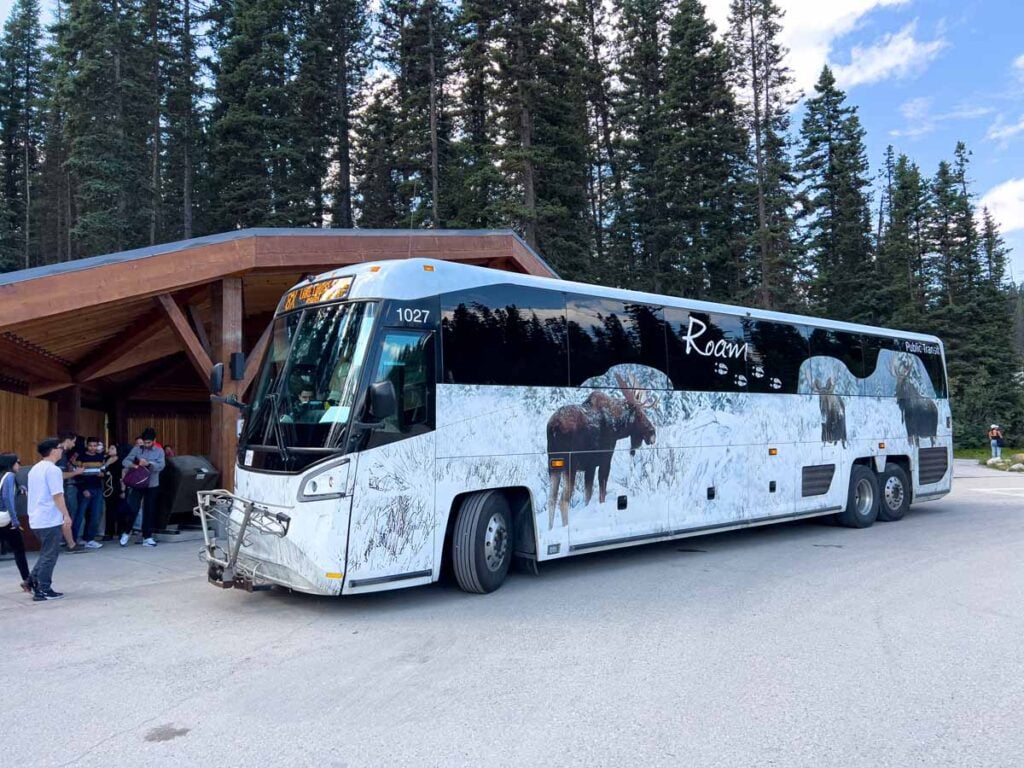 A Roam 8X transit bus picks up passengers at the Lake Louise bus stop in the lakeshore parking lot.