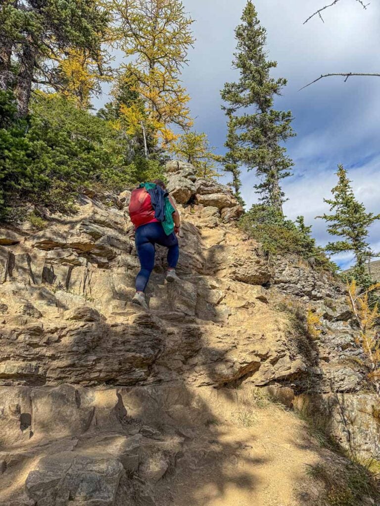 Celine Brewer hikes a steep, rocky section of the Devil's Thumb hiking trail near Lake Louise, Banff National Park.