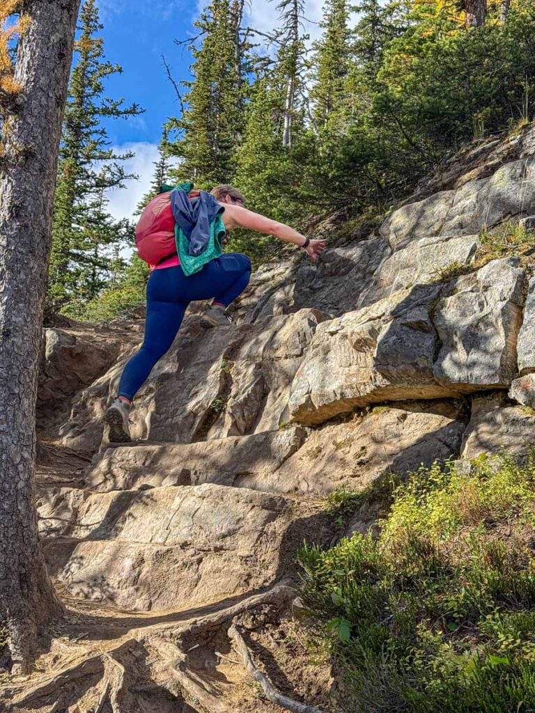 Celine Brewer, owner of TravelBanffCanada.com, climbs a very steep portion of the Devil's Thumb hike in Lake Louise.