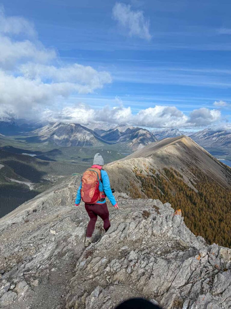 Celine Brewer hikes near the edge of a cliff while descending from the summit of the Tent Ridge Horseshoe Trail.