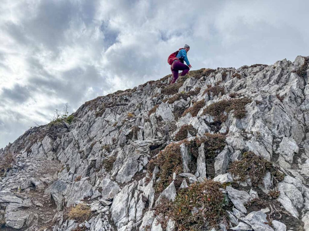 Celine Brewer, host of the Banff Travel Podcast, nears the top of a steep scramble on the Tent Ridge Horseshoe Trail in Kananaskis Country.