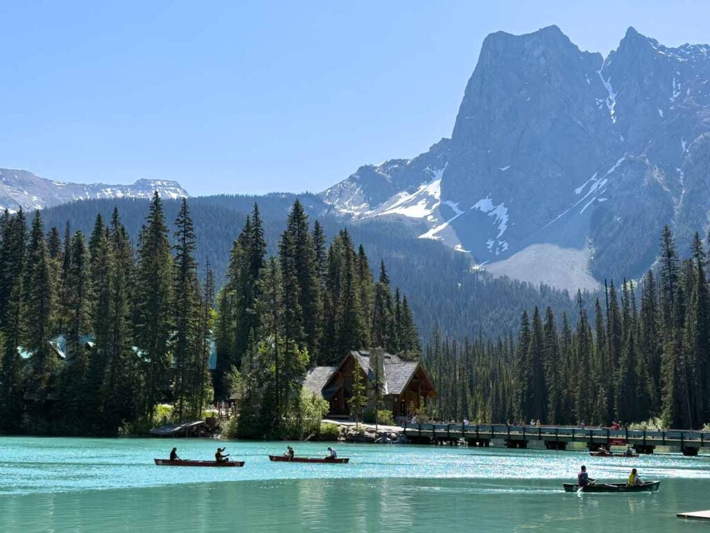 Red canoe rentals float past the famous bridge at Emerald Lake.