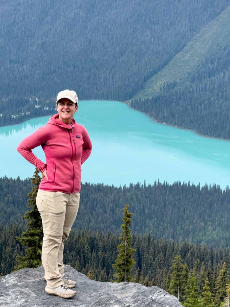 Celine Brewer, host of the Banff Travel Podcast, looks down on Emerald Lake from the Wapta Highline Trail.