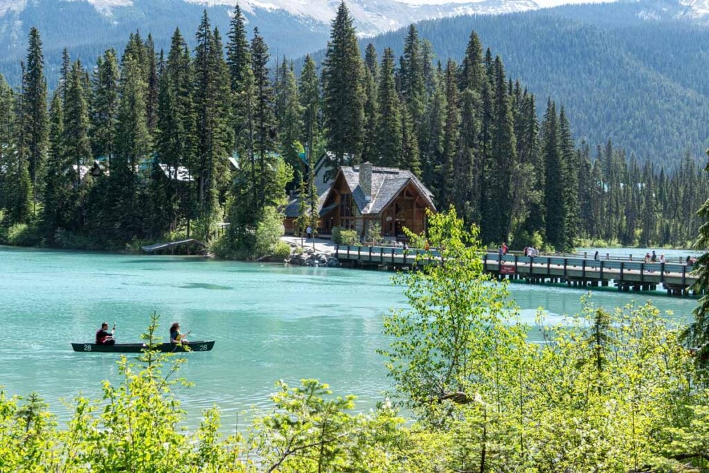 A red canoe floats past the Emerald Lake Lodge in Yoho National Park, Canada.
