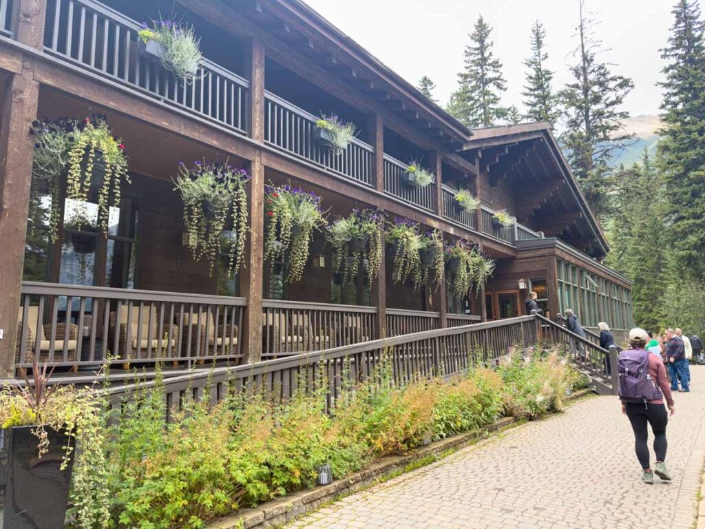 Celine Brewer, host of the Banff Travel Podcast, walks past the Emerald Lake Lodge at the end of the lakeshore trail.