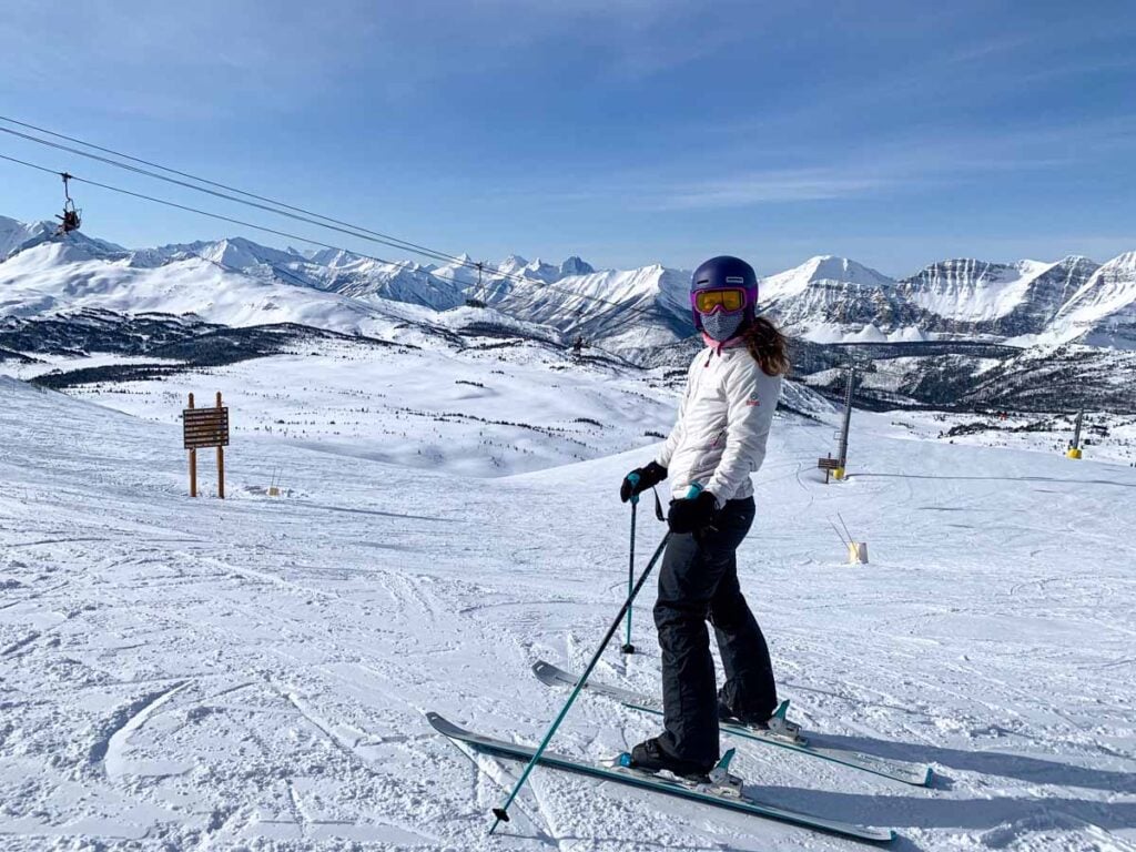 Celine Brewer, host of the Banff Travel Podcast, enjoys skiing on a bluebird day at Sunshine Village in Banff National Park.