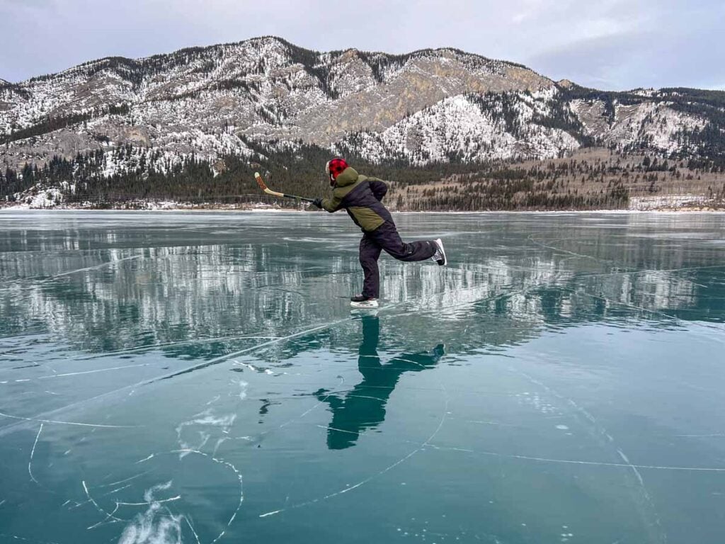 Dan Brewer plays ice hockey while skating on Barrier Lake in Kananaskis.