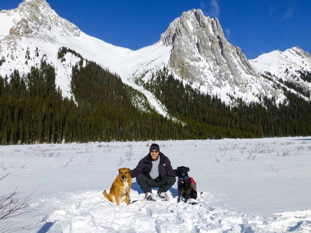 Dan Brewer, owner of TravelBanffCanada.com, unzips his jacket on a mild day while snowshoeing the Burstall Pass Trail in Kananaskis in February.